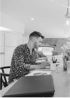 http://A%20designer%20working%20at%20a%20desk%20in%20the%20DecodingLeads%20studio